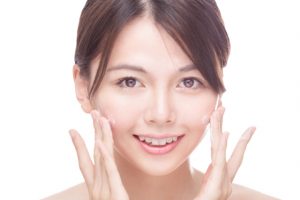 Asian Woman Applying Skin Moisturizer